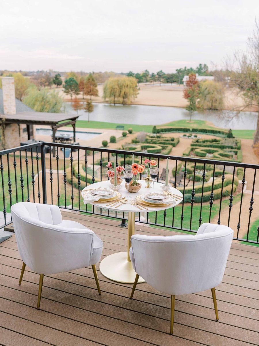 A balcony table overlooking the boxwood gardens and lake